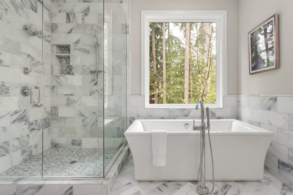 elegant custom shower beside a standalone bathtub in spa-like bathroom